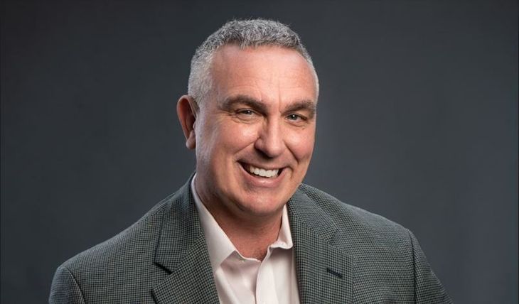 A man in a suit is smiling for the camera.