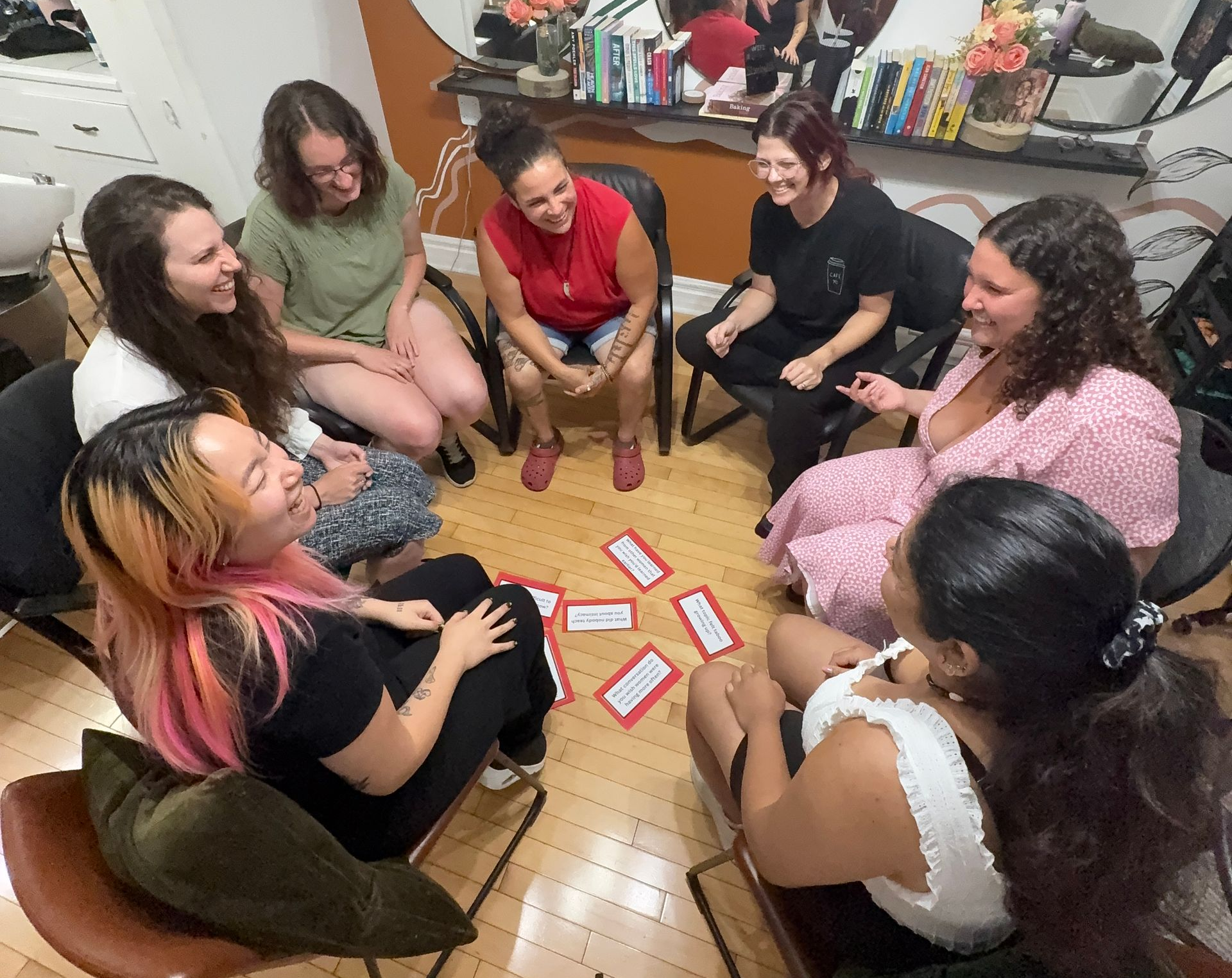 A group of women are sitting in a circle laughing.