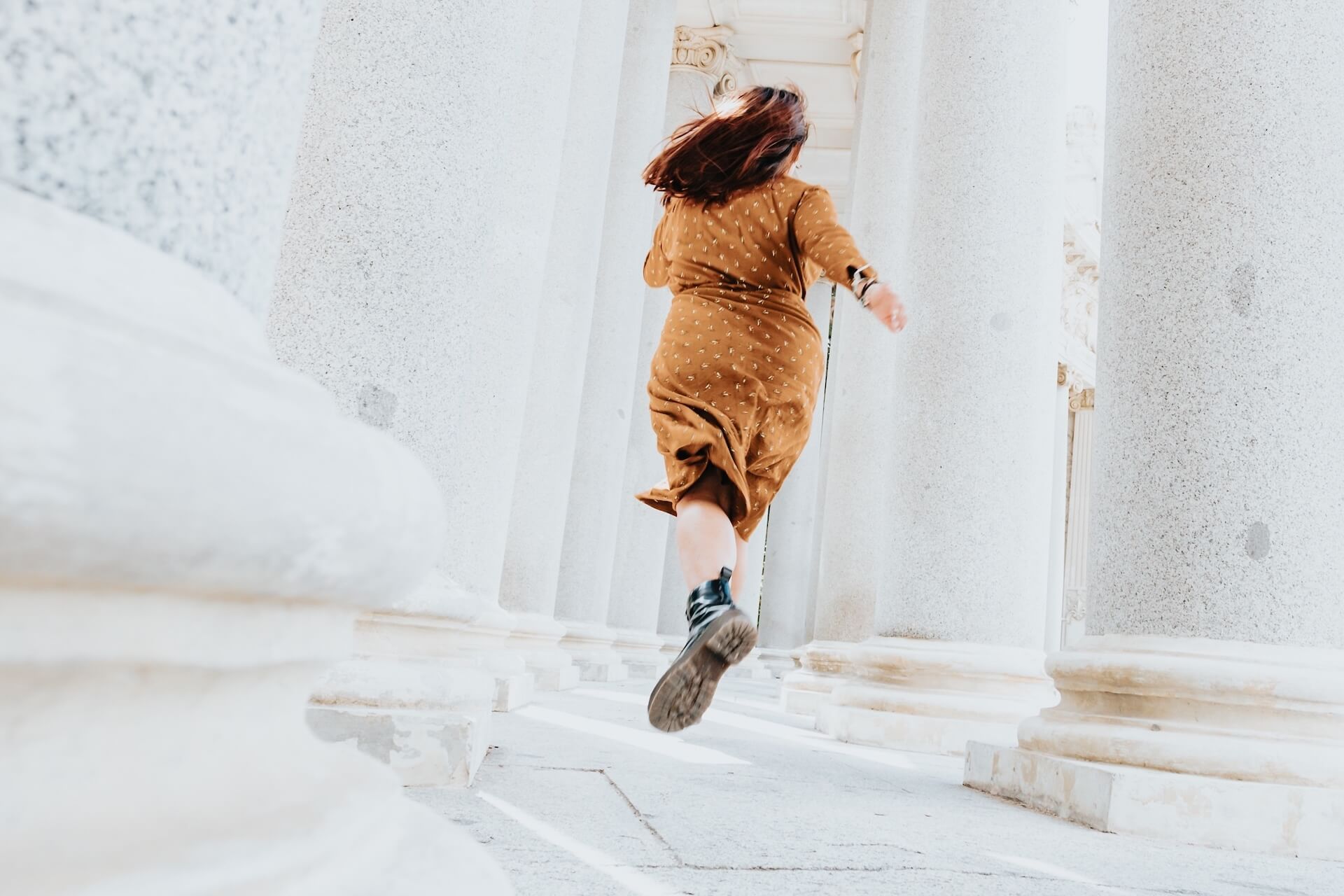A woman in a brown dress is running away