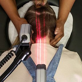 Medical laser treatment on a person’s neck and scalp with a handheld device
