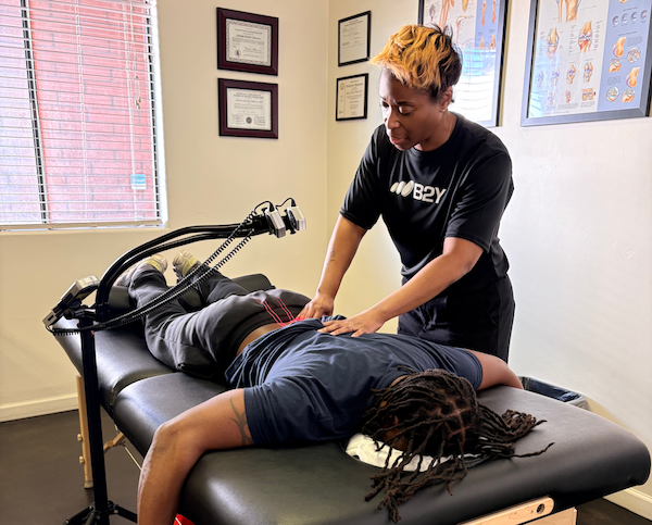 A person receiving back treatment from Dr. Natasha Williams in a clinic setting.