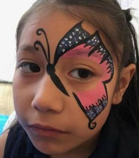 Child with butterfly face paint in black, pink, and white, close-up portrait