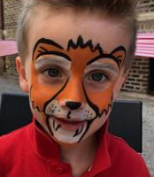 Child with orange face paint at a children's borthday party.