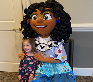 Child hugging a large mascot at a birthday party.