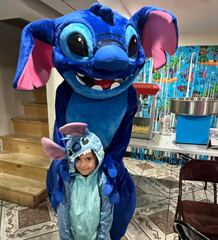 Lilo & Stitch mascot at a decorated childrens party.