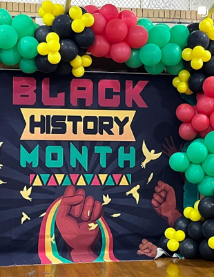 Black History Month banner with colorful balloons and raised fists on a dark backdrop.