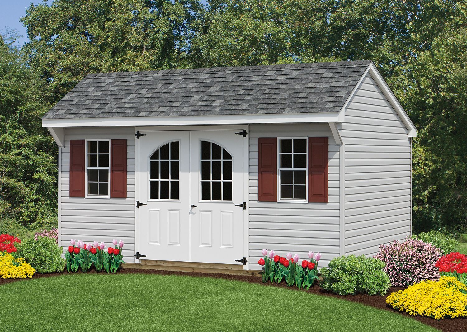 Gray shed with double doors, red shutters, and a green lawn with flowers.