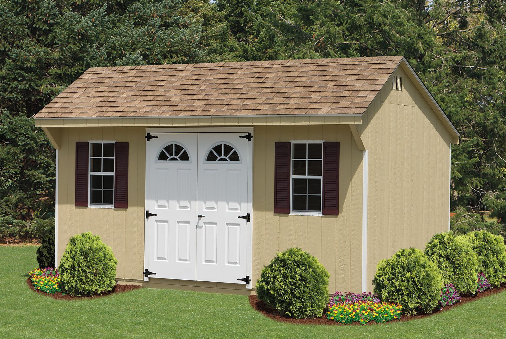 Tan shed with brown roof, white double doors, and windows with brown shutters, set in a yard with bushes.