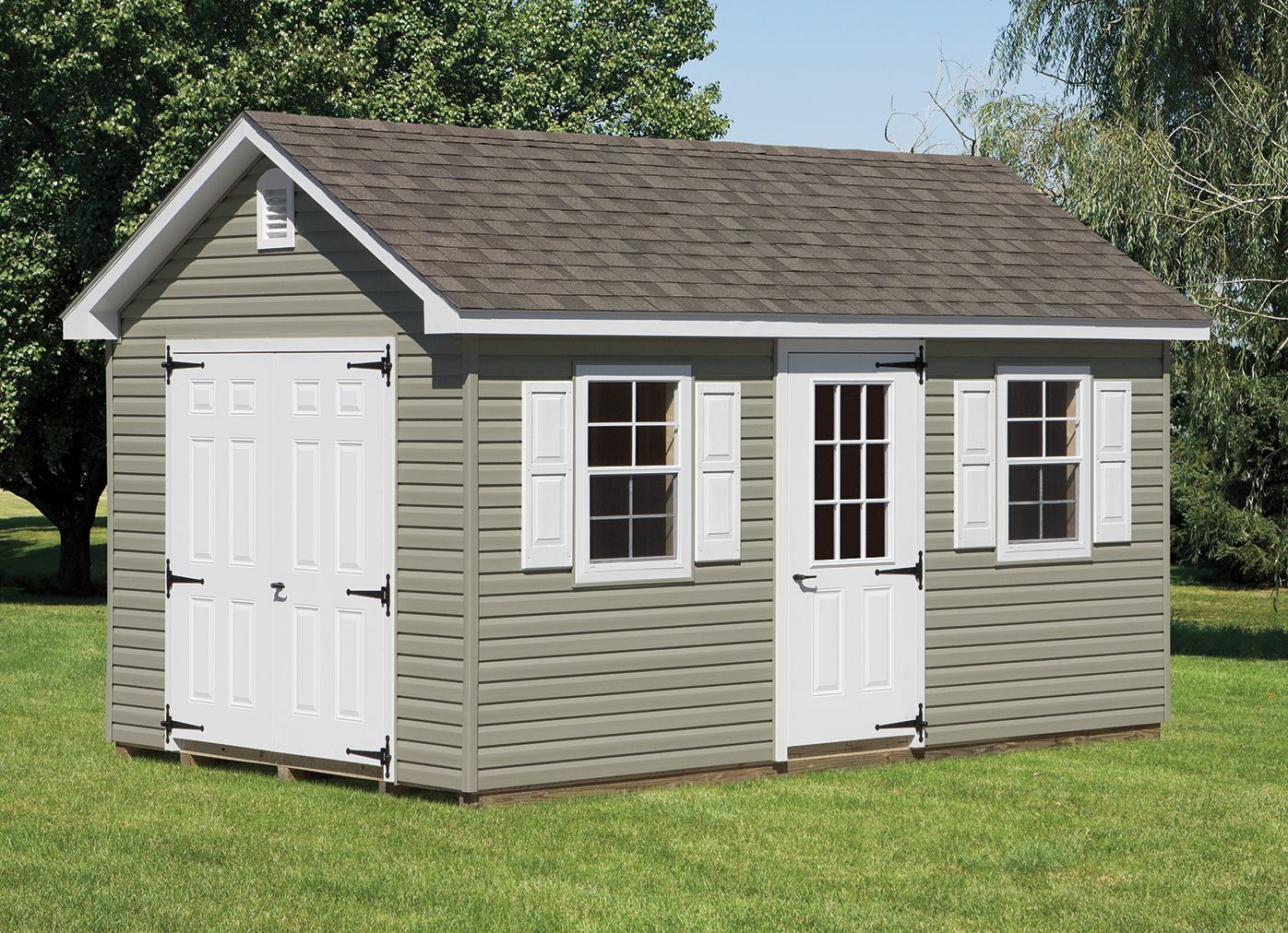 Gray storage shed with white doors, windows, and trim on a grassy lawn.