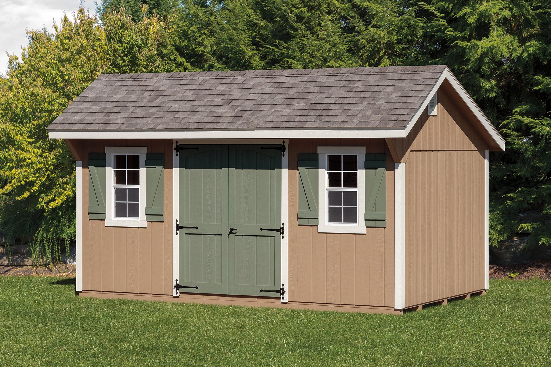 Tan wooden storage shed with green doors and shutters, two windows, and gray roof.