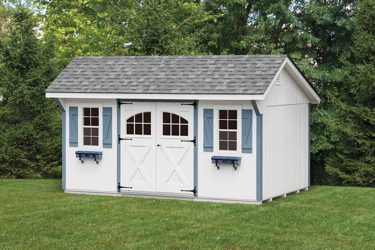 White shed with blue trim, gray roof, double doors, and two windows with blue shutters, set on grass.