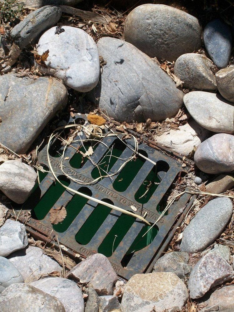 Surface drainage inlet set among river rock
