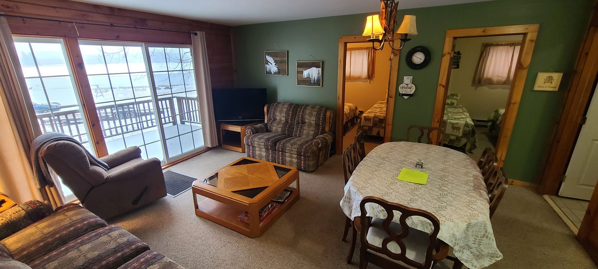 A living room with a couch , chairs , table and television.