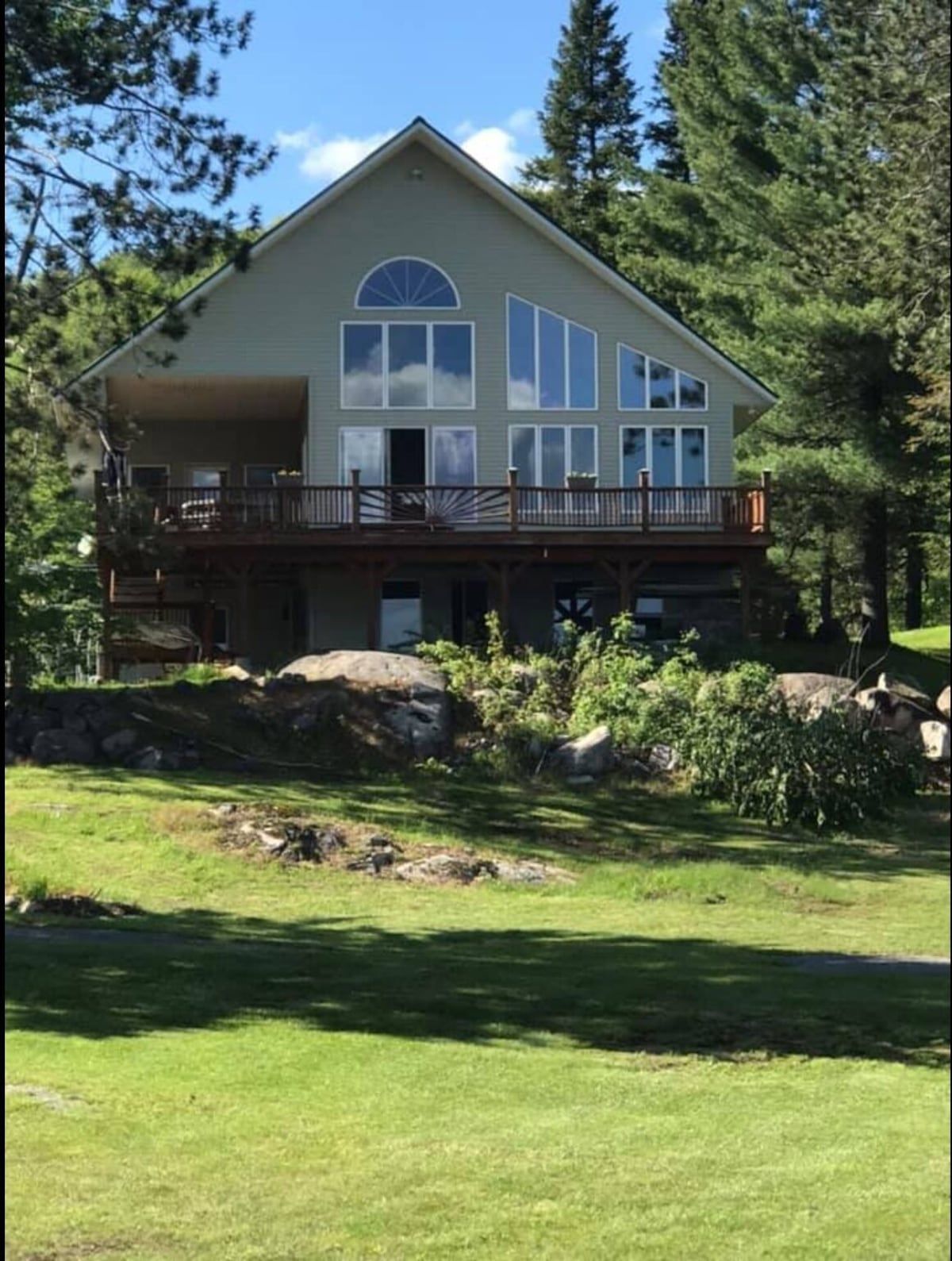 A large house with a lot of windows is surrounded by trees