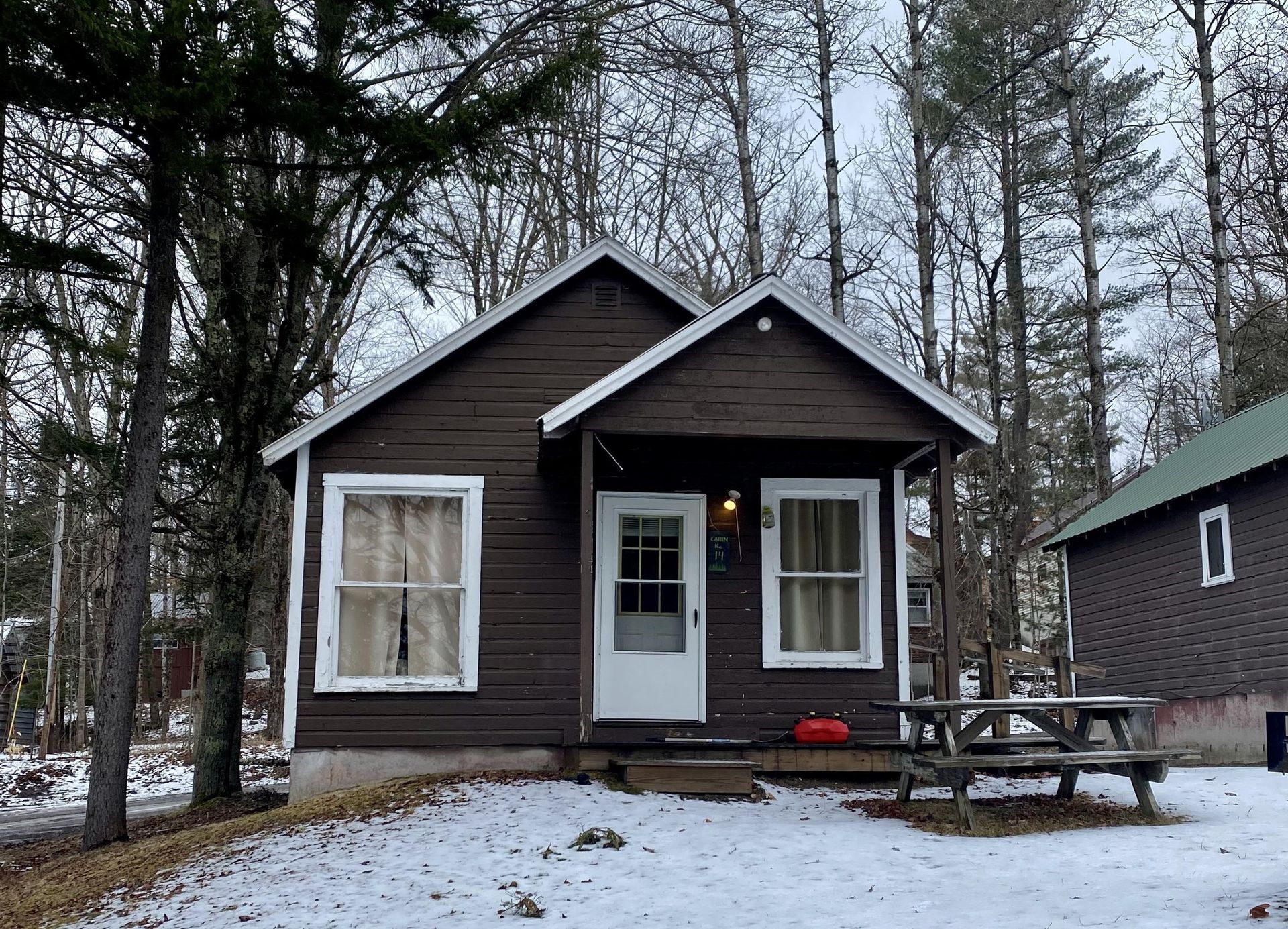 A small house with a picnic table in front of it
