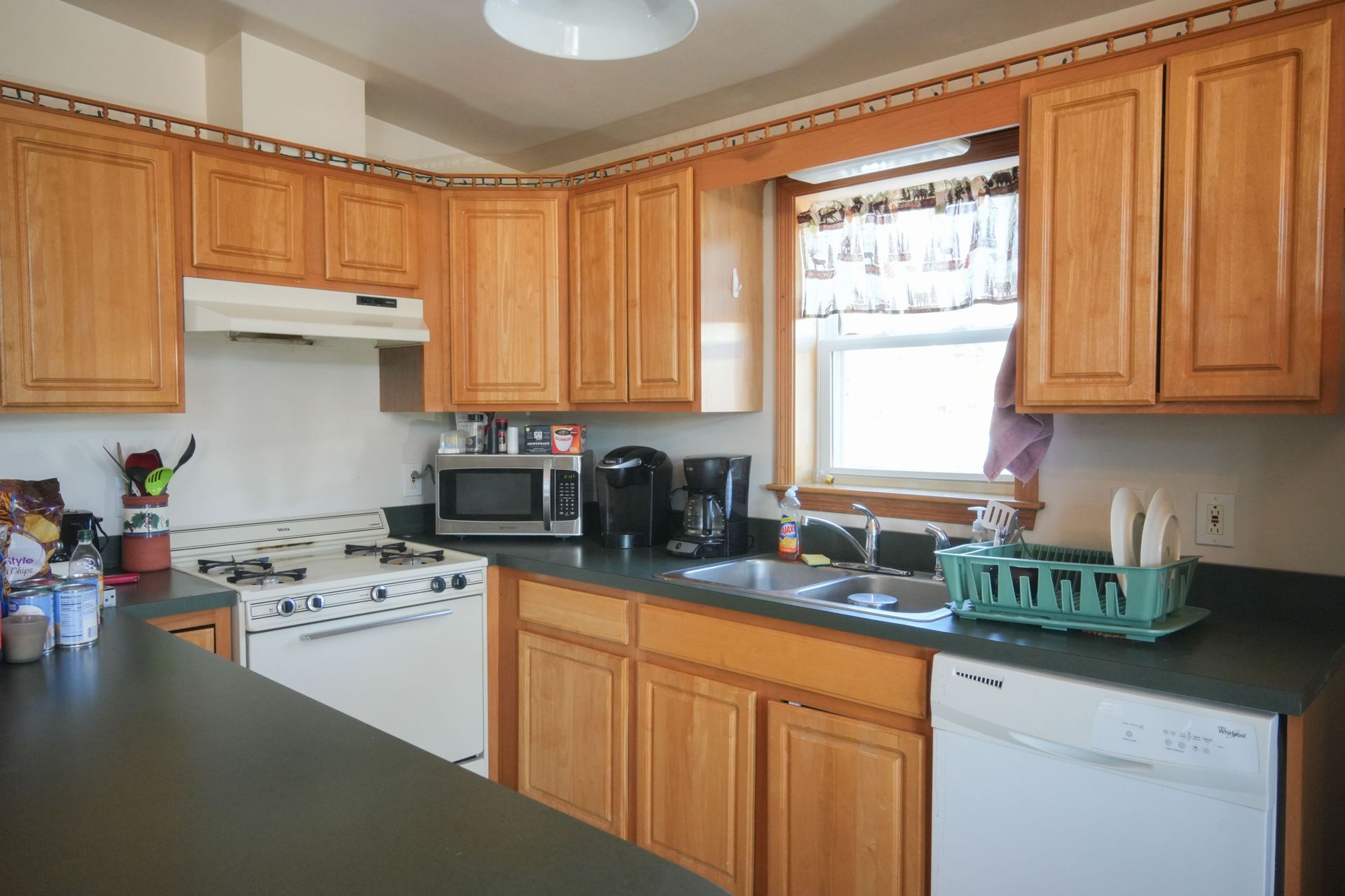 A kitchen with wooden cabinets and white appliances