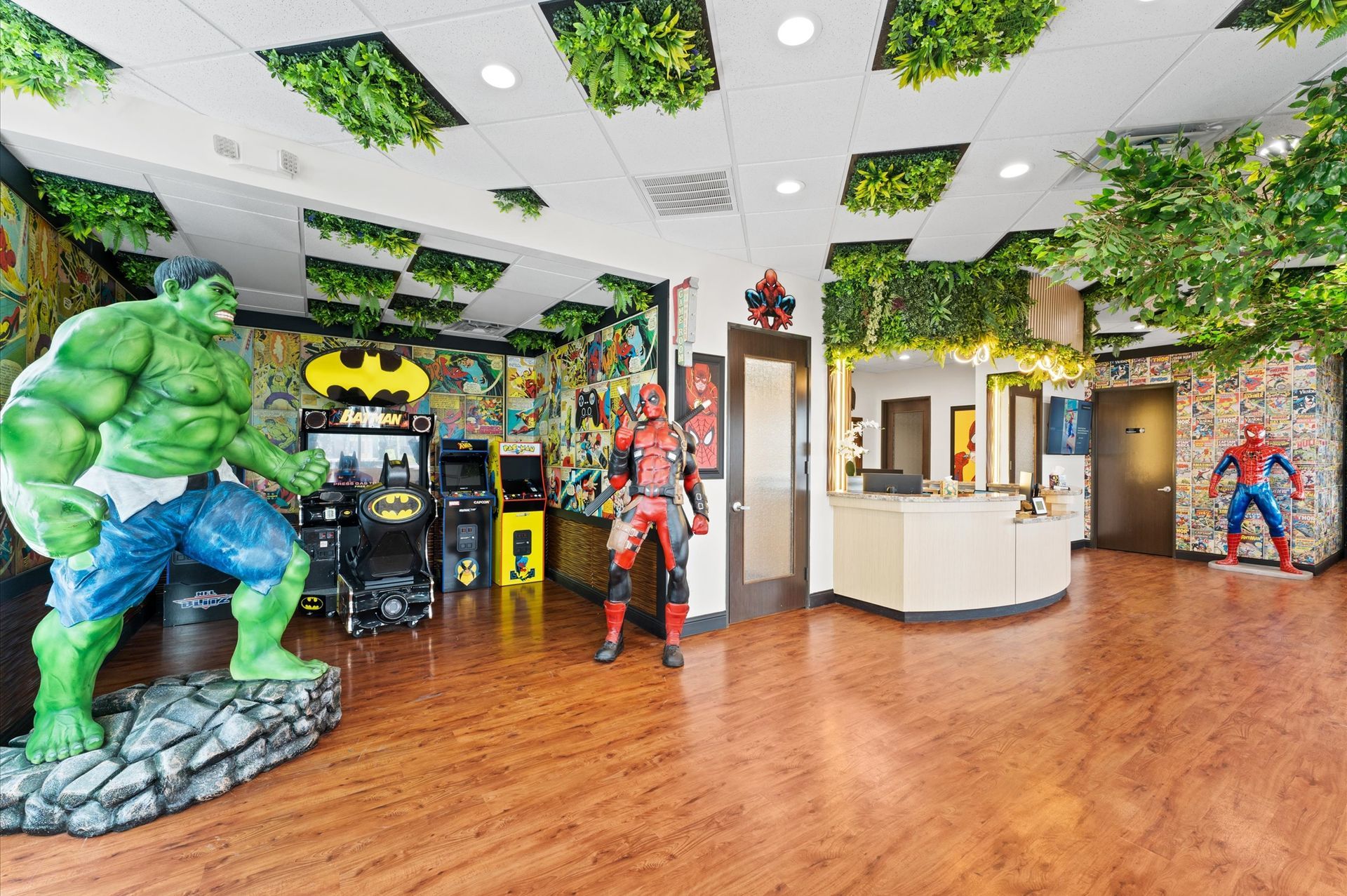 A room with a statue of the hulk , batman , and deadpool.
