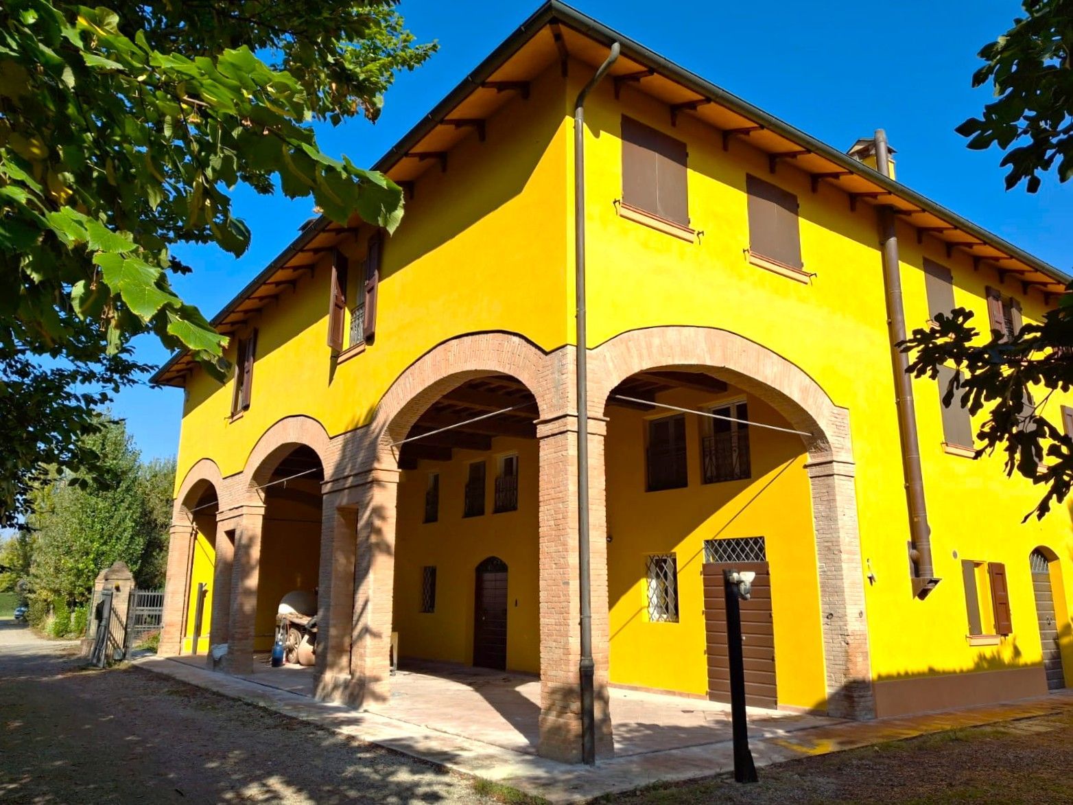 Cucina moderna, bianca, con mobili, elettrodomestici e una finestra con persiane.