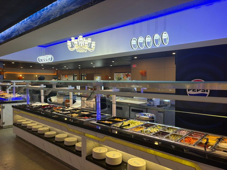 Buffet counter with assorted dishes under bright lights in a modern restaurant interior