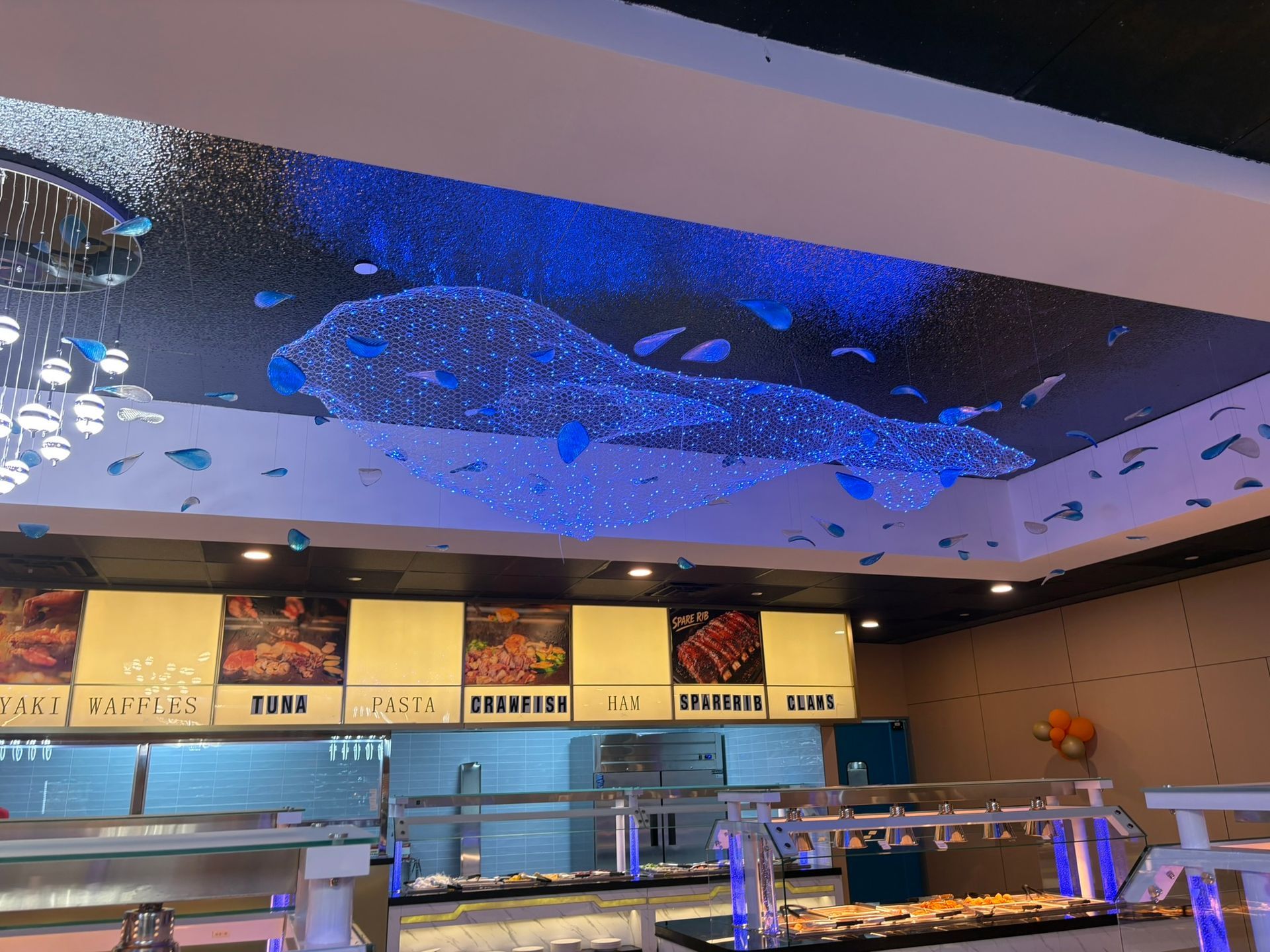 Modern restaurant counter with menu boards and blue-lit ceiling decor