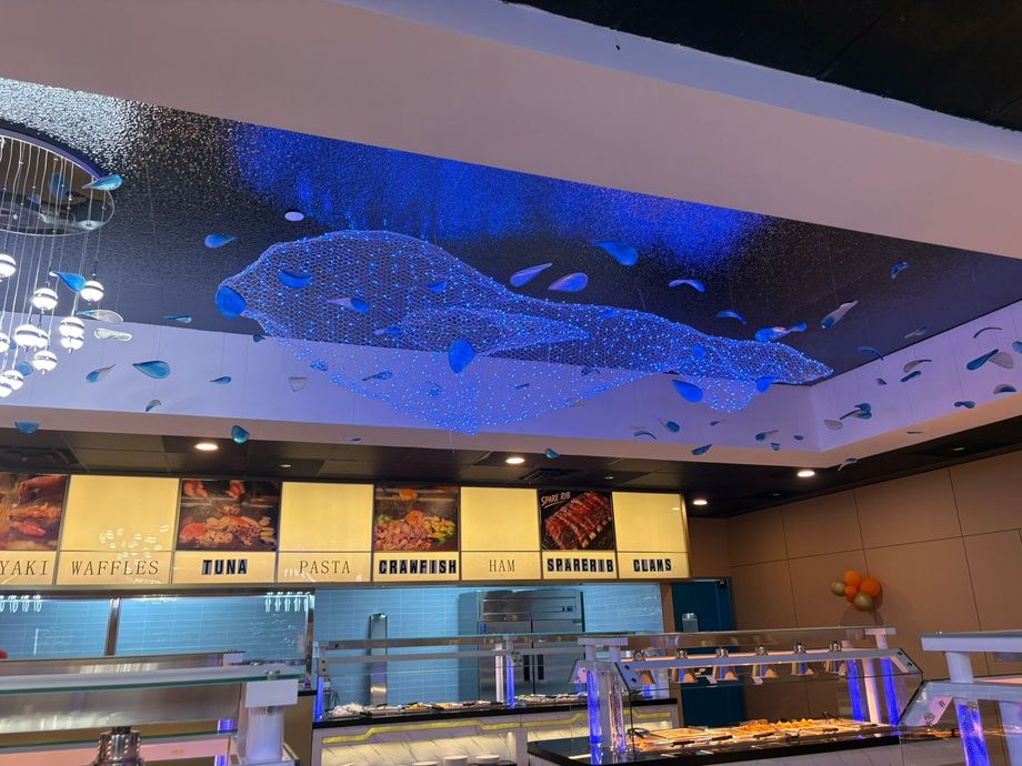 Modern restaurant counter with menu boards and blue-lit ceiling decor
