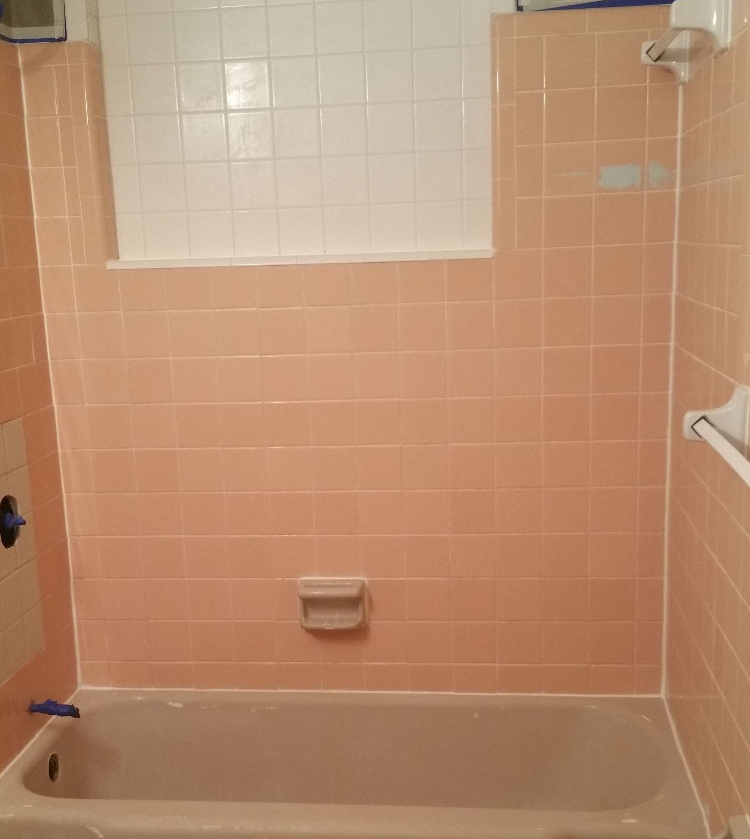 A white bathtub with brown stains on the bottom of it.