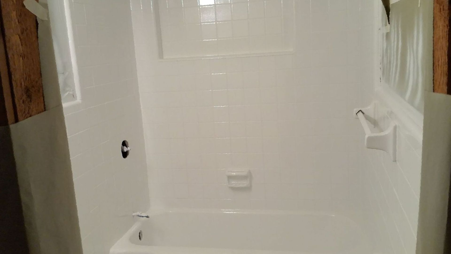 A white bathtub with a drain on the side of it.