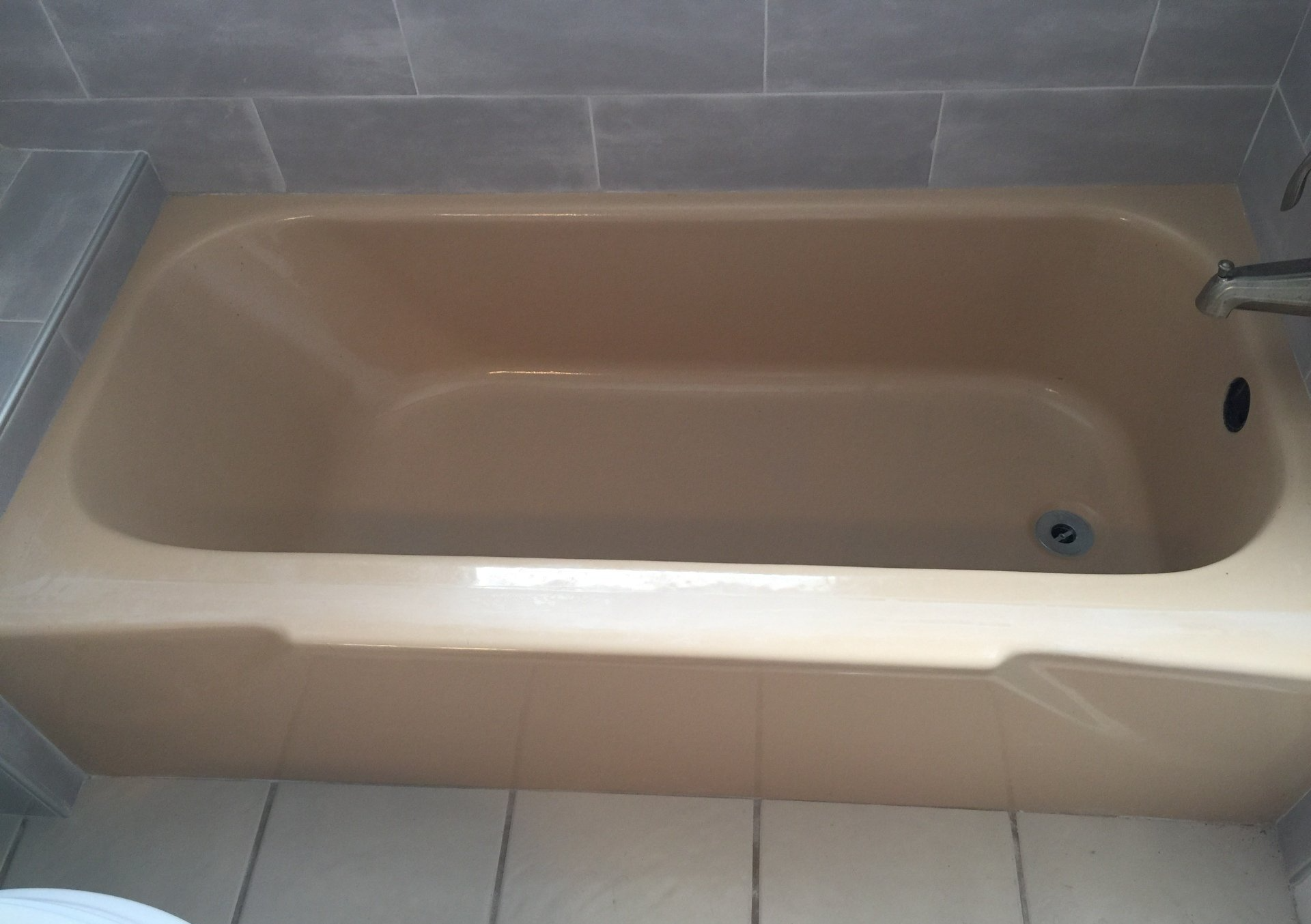An empty bathtub in a bathroom next to a toilet.