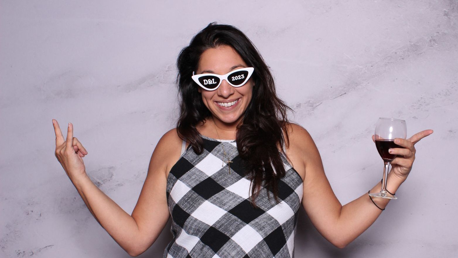 a woman wearing sunglasses and holding a glass of wine