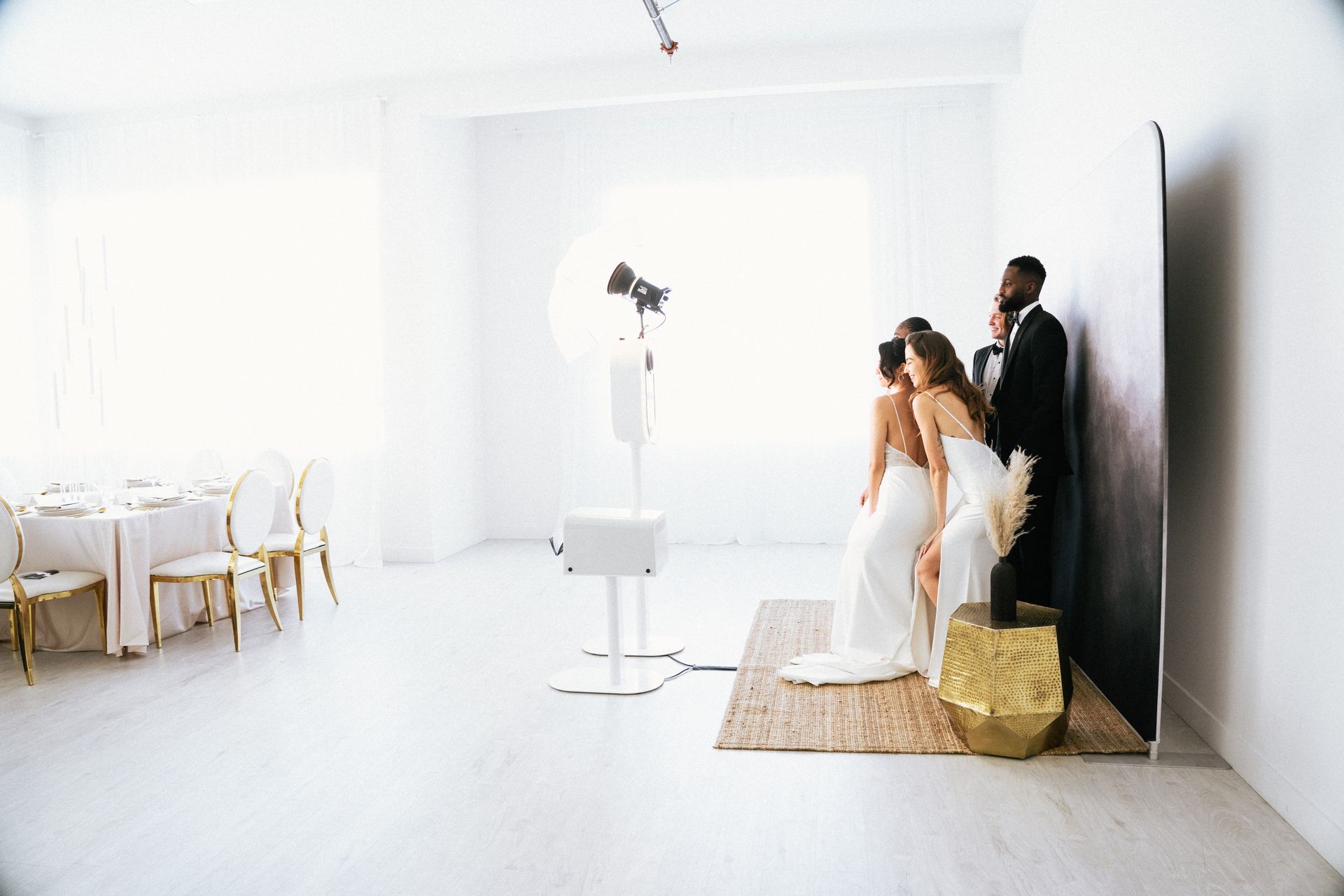 a bride and her bridesmaids are posing for a picture in front of a large chandelier .