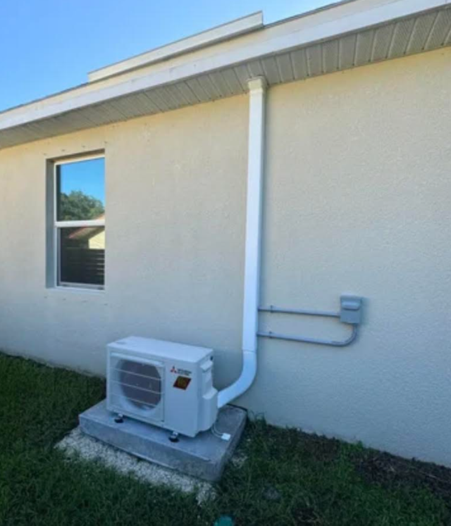 Technician servicing rooftop HVAC unit beside a red satellite dish