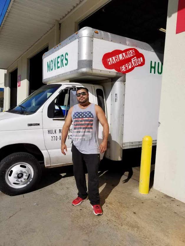 A man is standing in front of a moving truck.