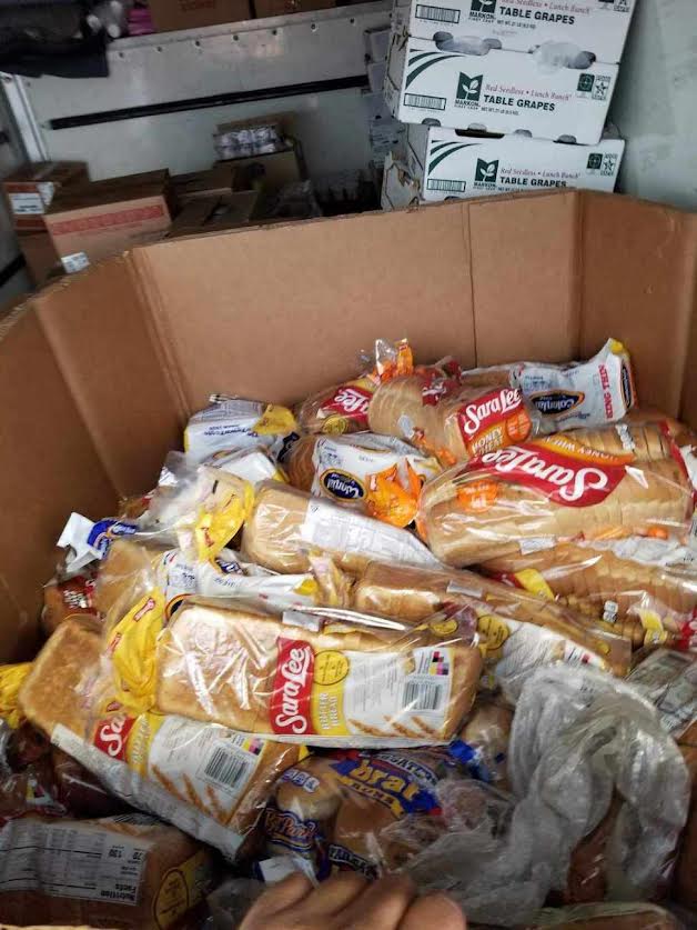 A cardboard box filled with lots of bread.