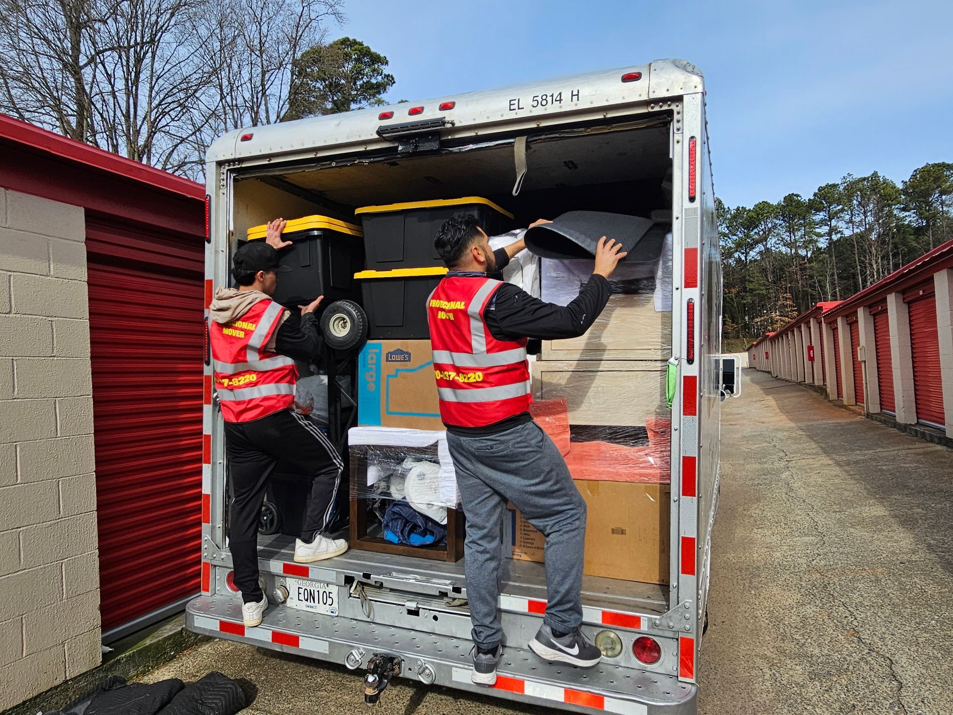 A man is carrying a large piece of furniture into a moving truck.