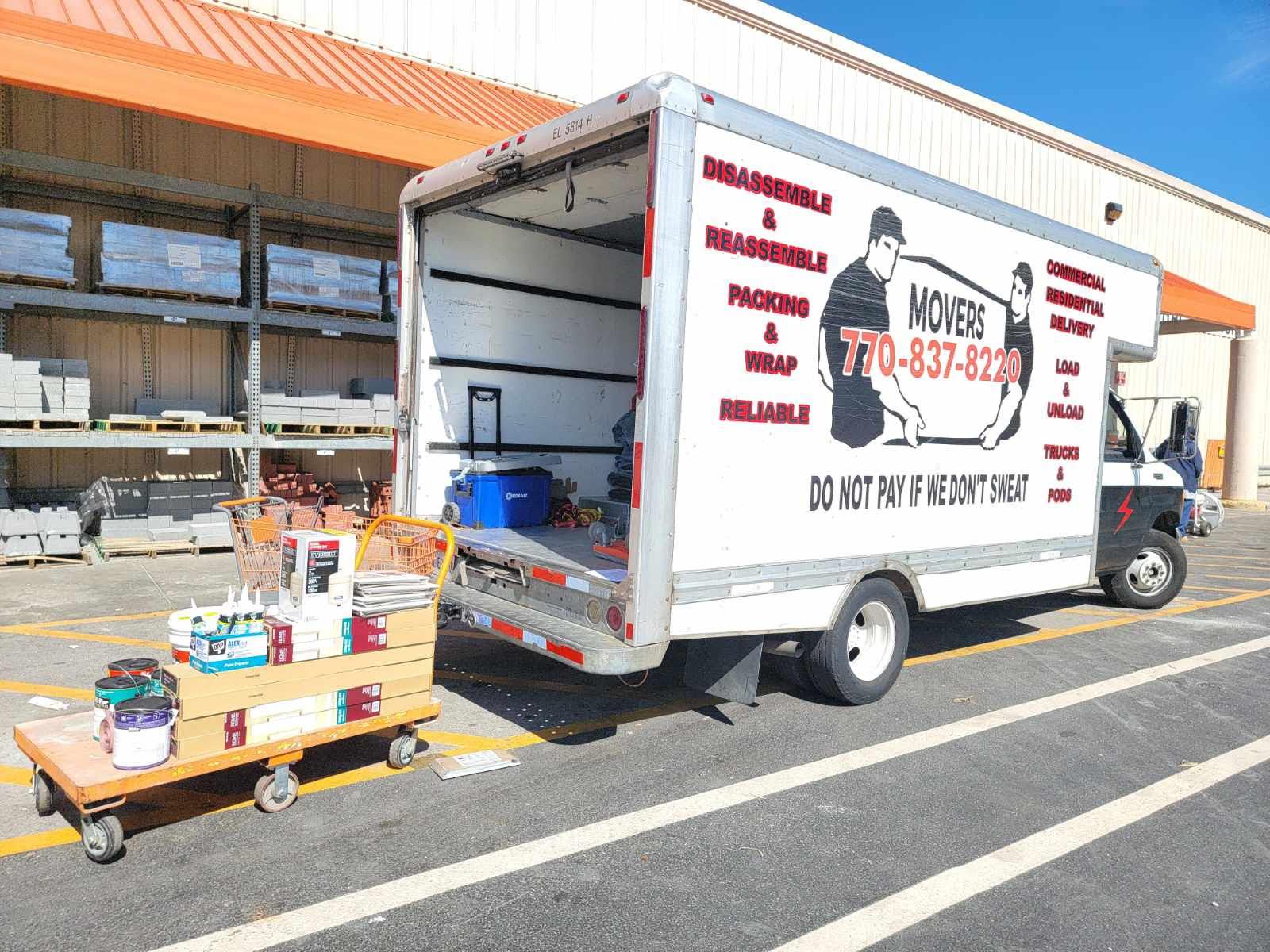A moving truck is parked in front of a store.