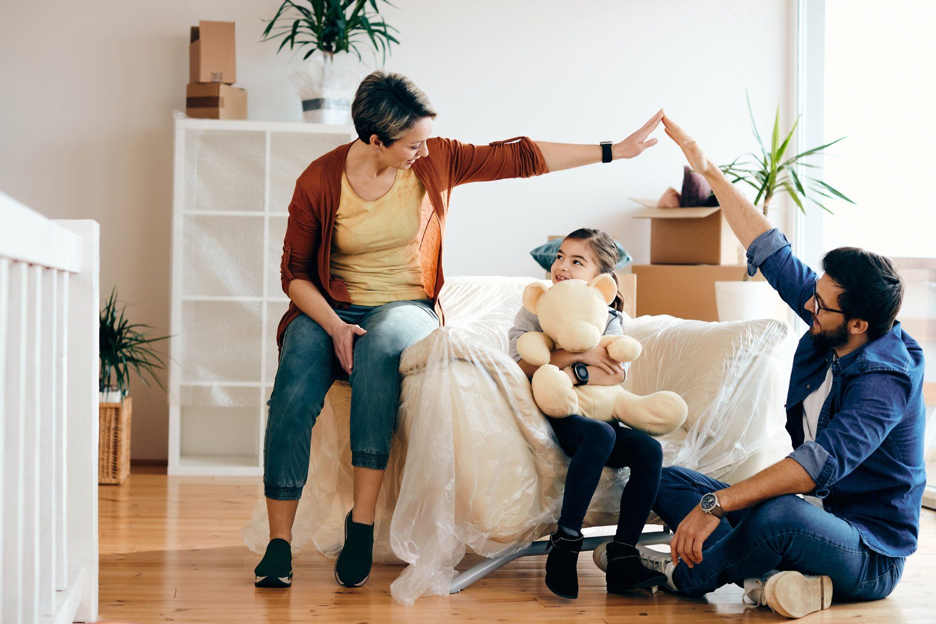 A family is giving each other a high five in their new home.
