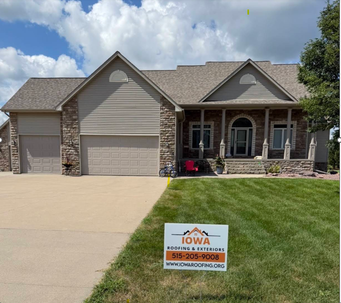 Home with a new asphalt shingle roof and an Iowa Roofing yard sign in the yard.