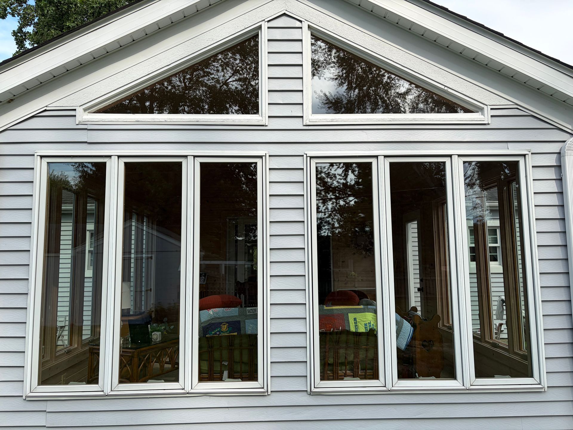 White house sunroom with large sliding glass doors and a peaked gable window