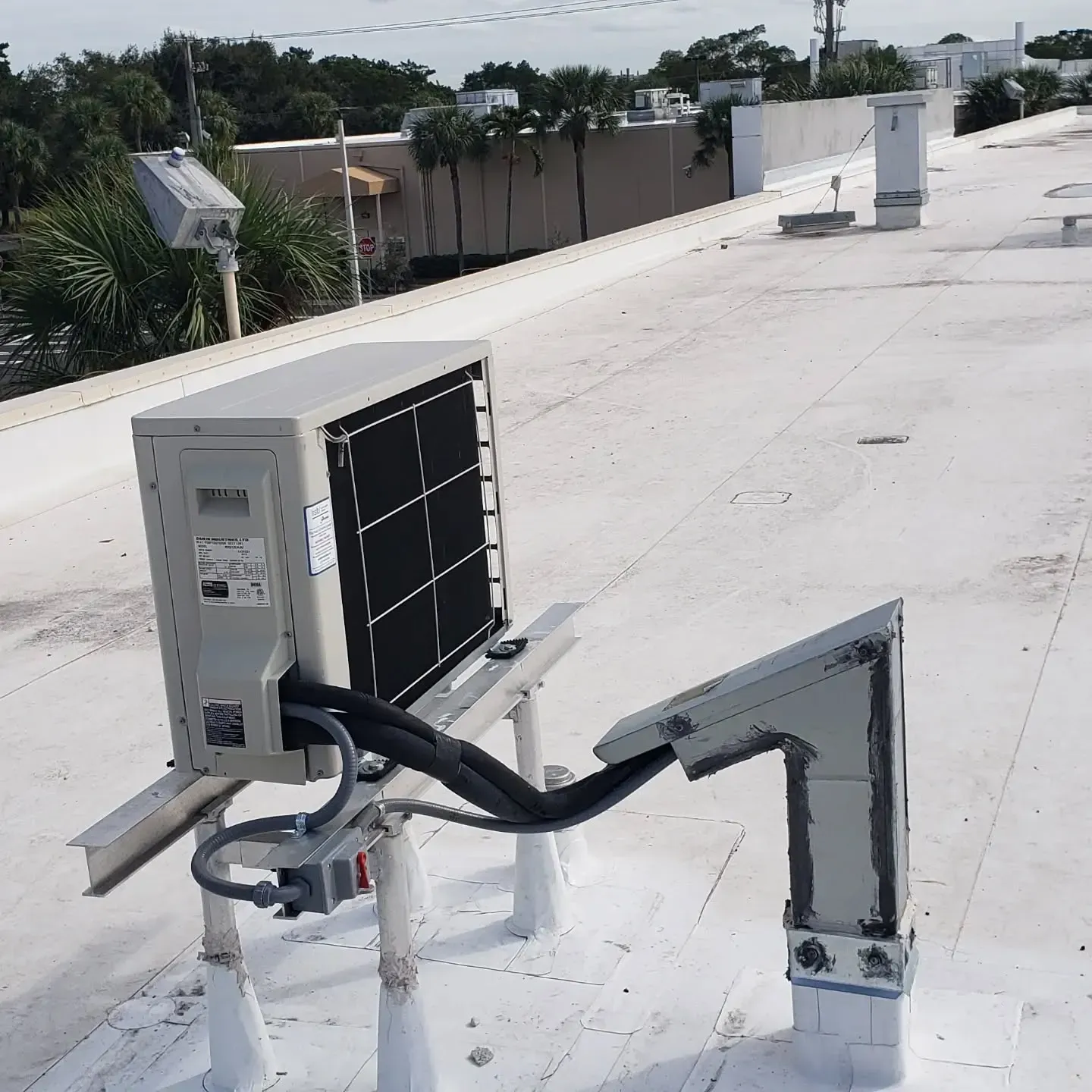 An air conditioner is sitting on top of a white roof