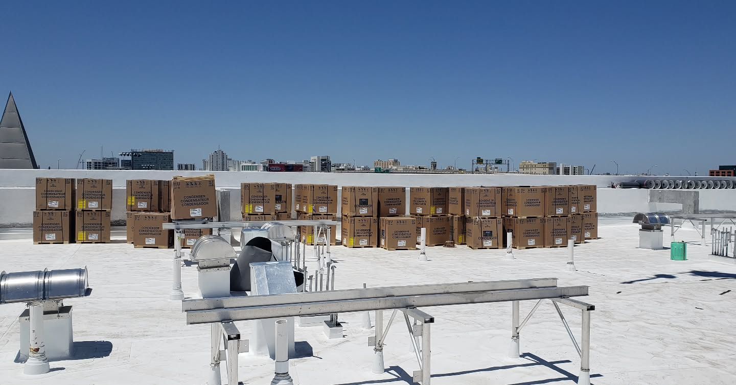 A row of boxes are sitting on top of a white roof.