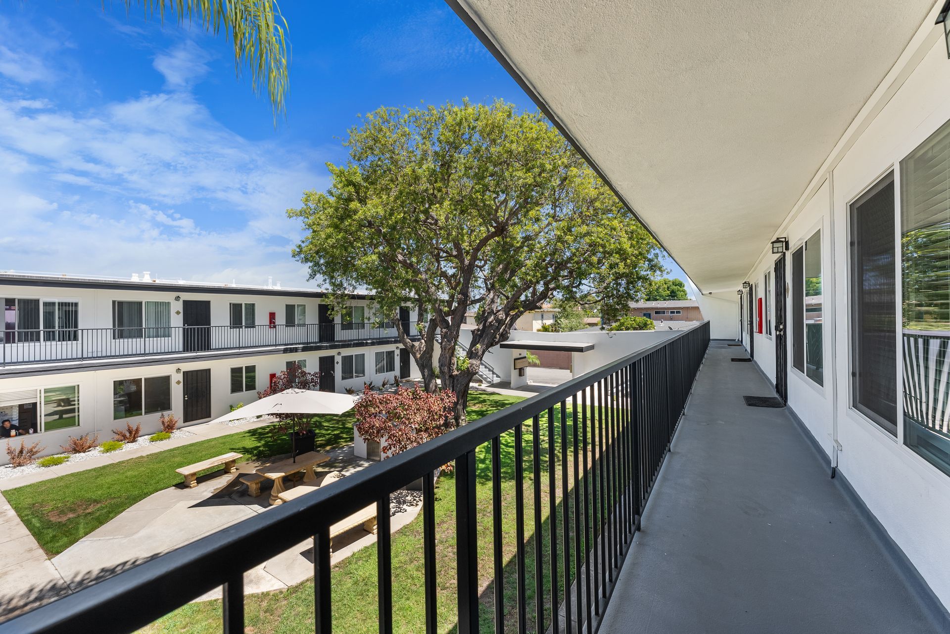 balcony view over courtyard with trees and table
