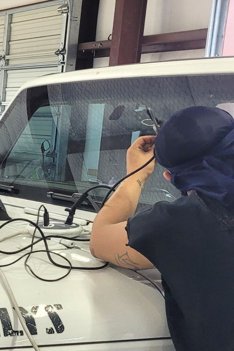 Technician using GlasWeld vacuum injector on a windshield rock chip to prevent spreading