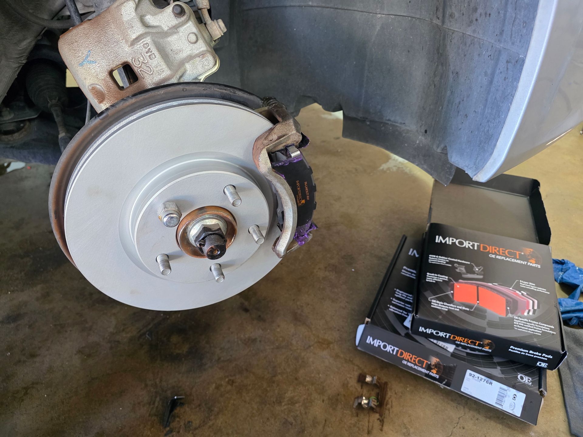 Fresh high-carbon brake rotor and Import Direct ceramic brake pads installed with anti-squeal lube at Quicker Sticker in College Station, TX