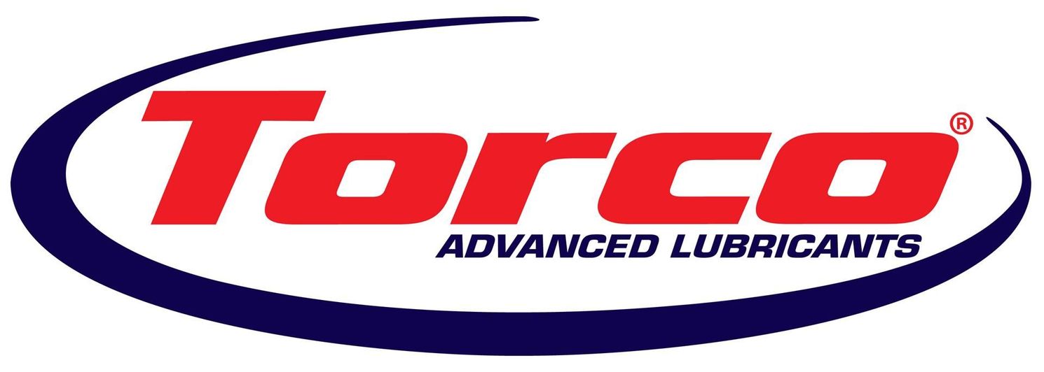 Torco Advanced Lubricants logo in red, blue, and whiteSilver and neon yellow sports car with oversized rear wing parked beside a white wall. | Pacific German