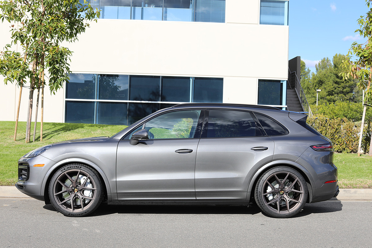 Gray SUV parked outside a modern building on a sunny daySilver and neon yellow sports car with oversized rear wing parked beside a white wall. | Pacific German