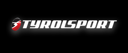 Tyrolsport logo in white and red on a black backgroundSilver and neon yellow sports car with oversized rear wing parked beside a white wall. | Pacific German