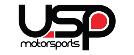 USP Motorsports logo in black and red text on a white backgroundSilver and neon yellow sports car with oversized rear wing parked beside a white wall. | Pacific German