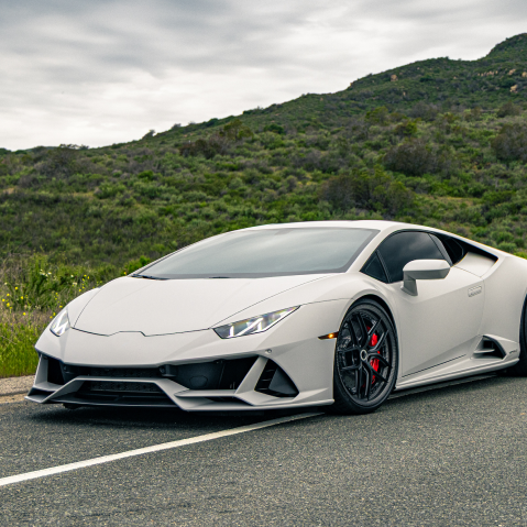 Silver Lamborghini sports car parked on a road with green hills in the background | Pacific Germany