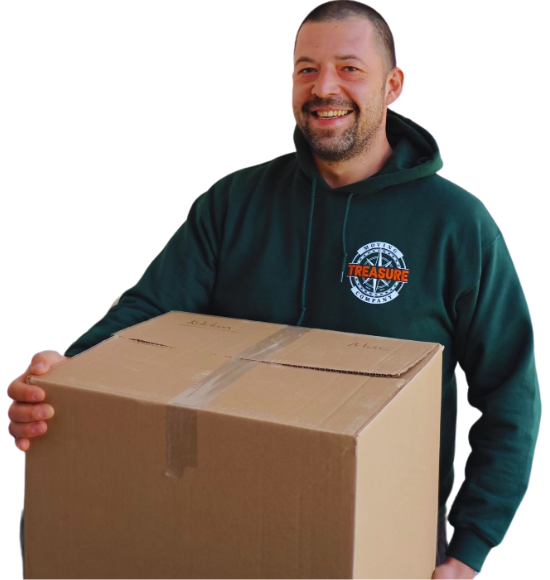 Man in green hoodie holding a cardboard box, smiling.