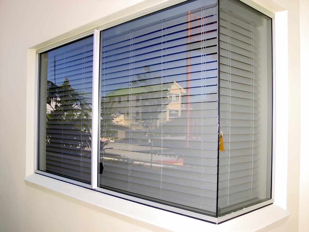 A Window With Blinds on It is on a White Wall — Maryborough Bay Glass & Aluminium in Maryborough, QLD